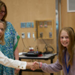 Board Chair Helen Gilbert congratulates one of the 2026 District Speech Contest top 3. Photo credit Adam Winn